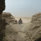 Obi-Wan Kenobi seen from the back, facing out toward the sand dunes on Tatooine.